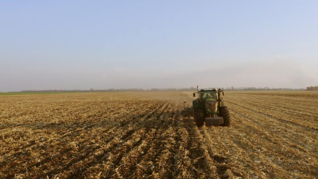 Green tractor working on field.